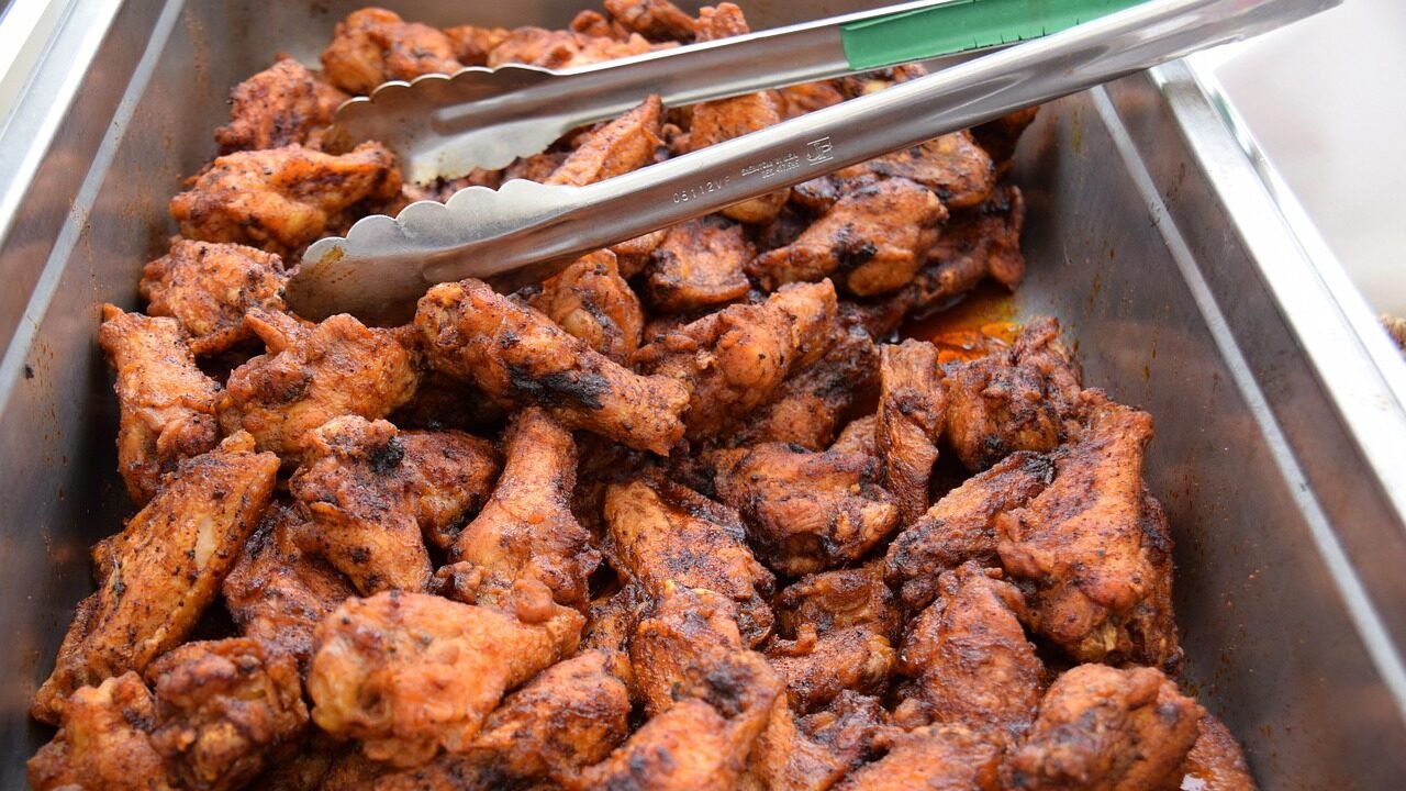 a big metal serving tray full of chicken wings